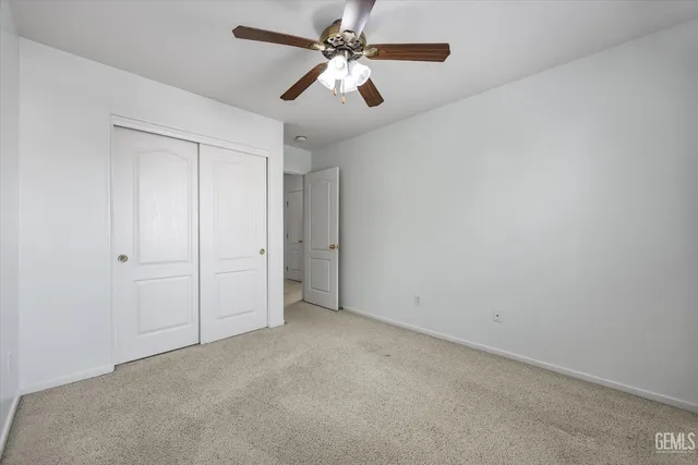 an empty room with a window and a fan