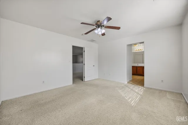 an empty room with ceiling fan and window
