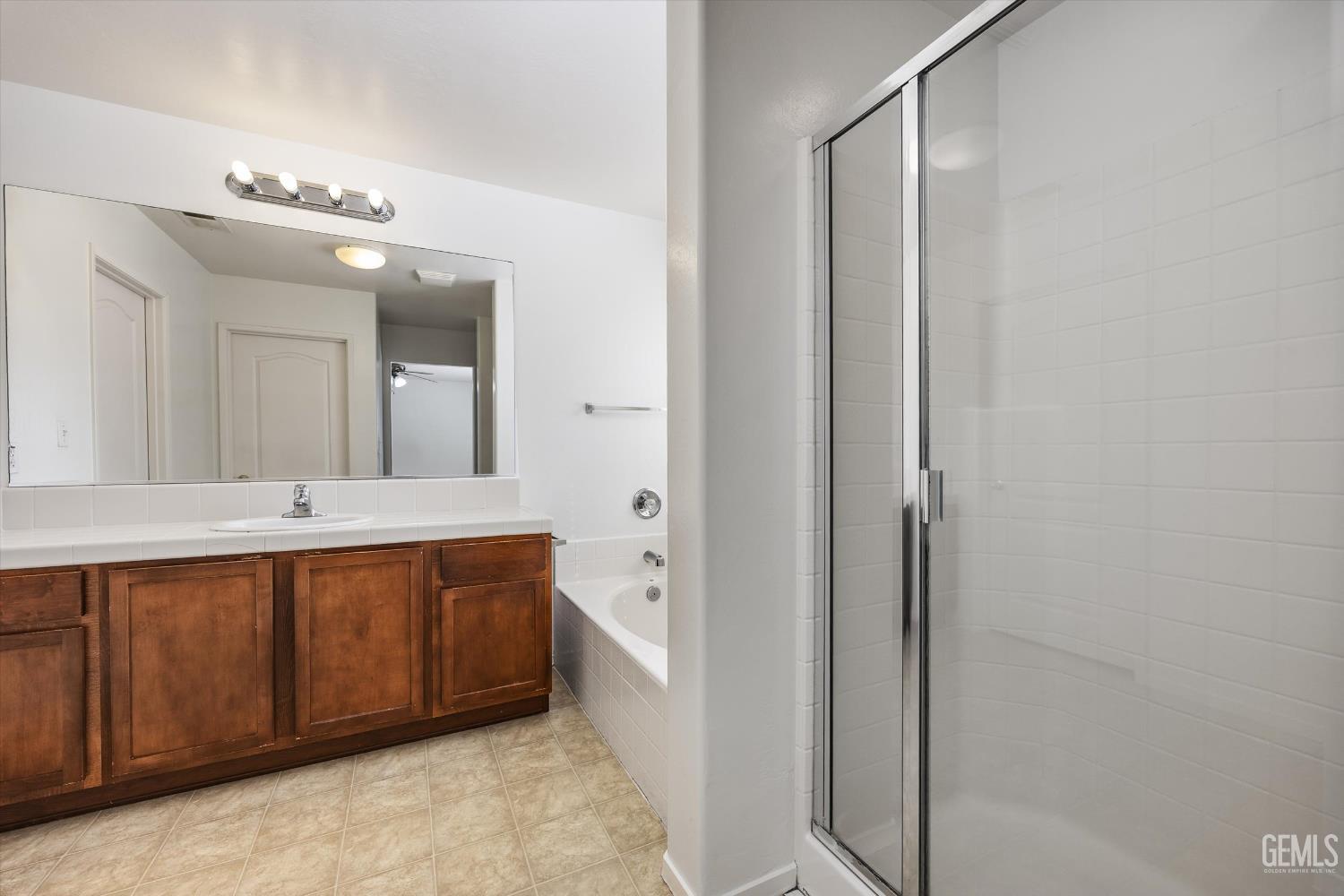 Undisclosed Address Bakersfield, CA 93312 - Photo 34 of 42 a spacious bathroom with a double vanity sink a mirror and a shower