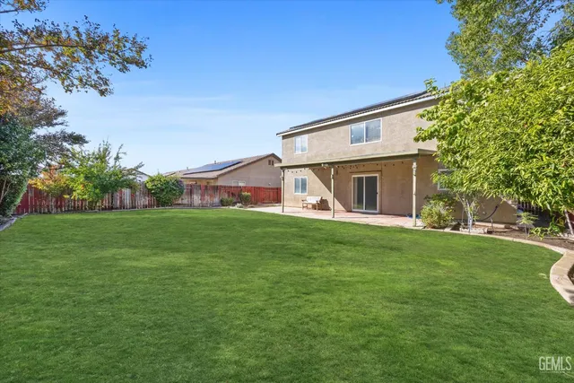 a view of a backyard with table and chairs with wooden fence