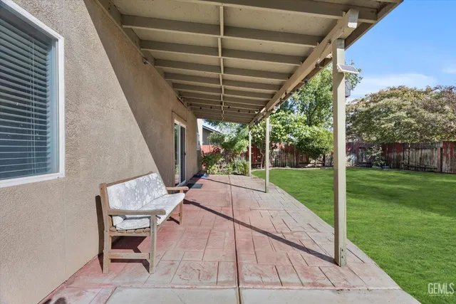 a view of a backyard with potted plants and large trees