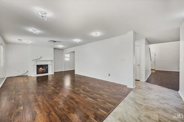 an empty room with wooden floor and fireplace