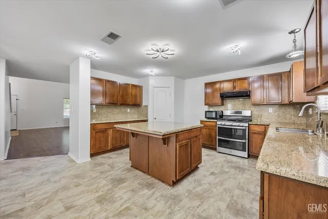 a kitchen with stainless steel appliances granite countertop a stove oven and a refrigerator
