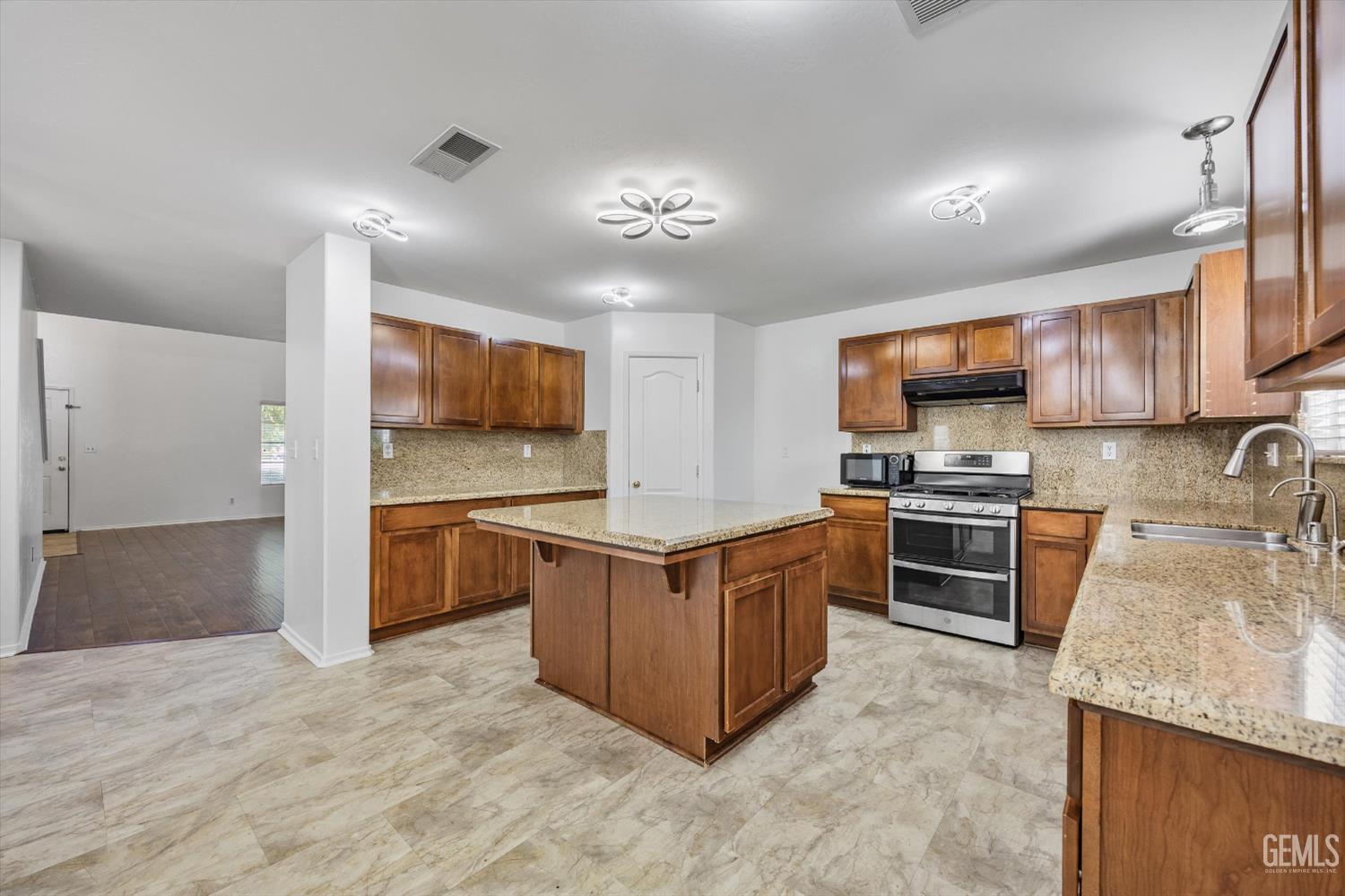 Undisclosed Address Bakersfield, CA 93312 - Photo 10 of 42 a kitchen with stainless steel appliances granite countertop a stove oven and a refrigerator