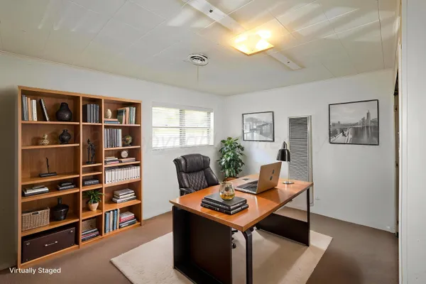 a living room with furniture a bookshelf and a window