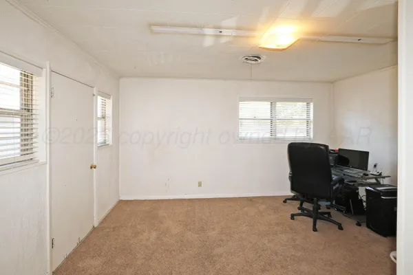 a view of a workspace with furniture and a window