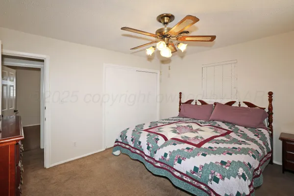 a bedroom with a bed and painting on the wall