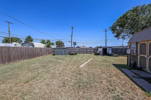a view of a backyard with wooden fence