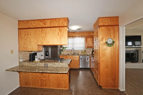 a kitchen with stainless steel appliances granite countertop a refrigerator and a sink