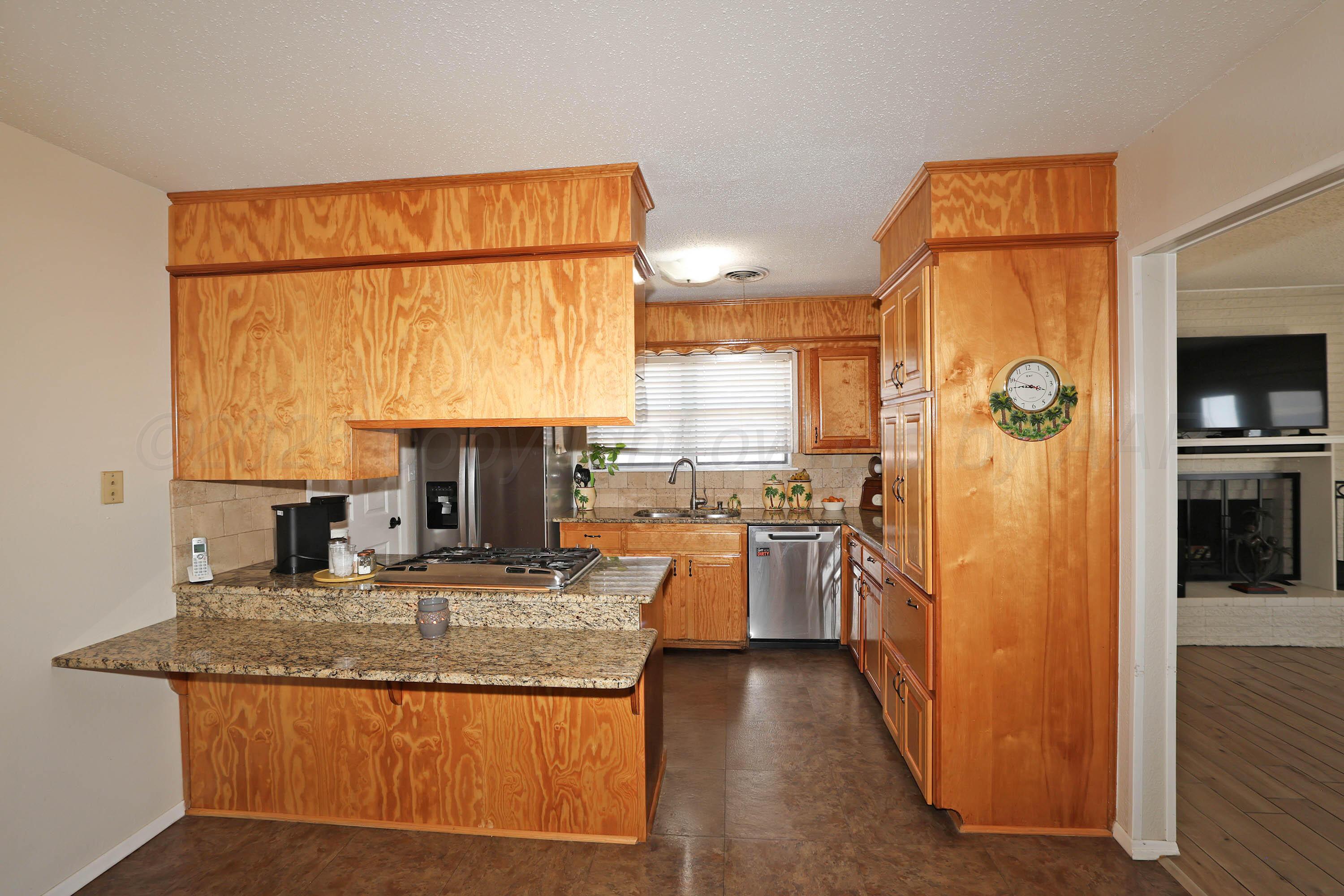 5811 Oregon Trail Amarillo, TX 79109 - Photo 6 of 22 a kitchen with stainless steel appliances granite countertop a refrigerator and a sink
