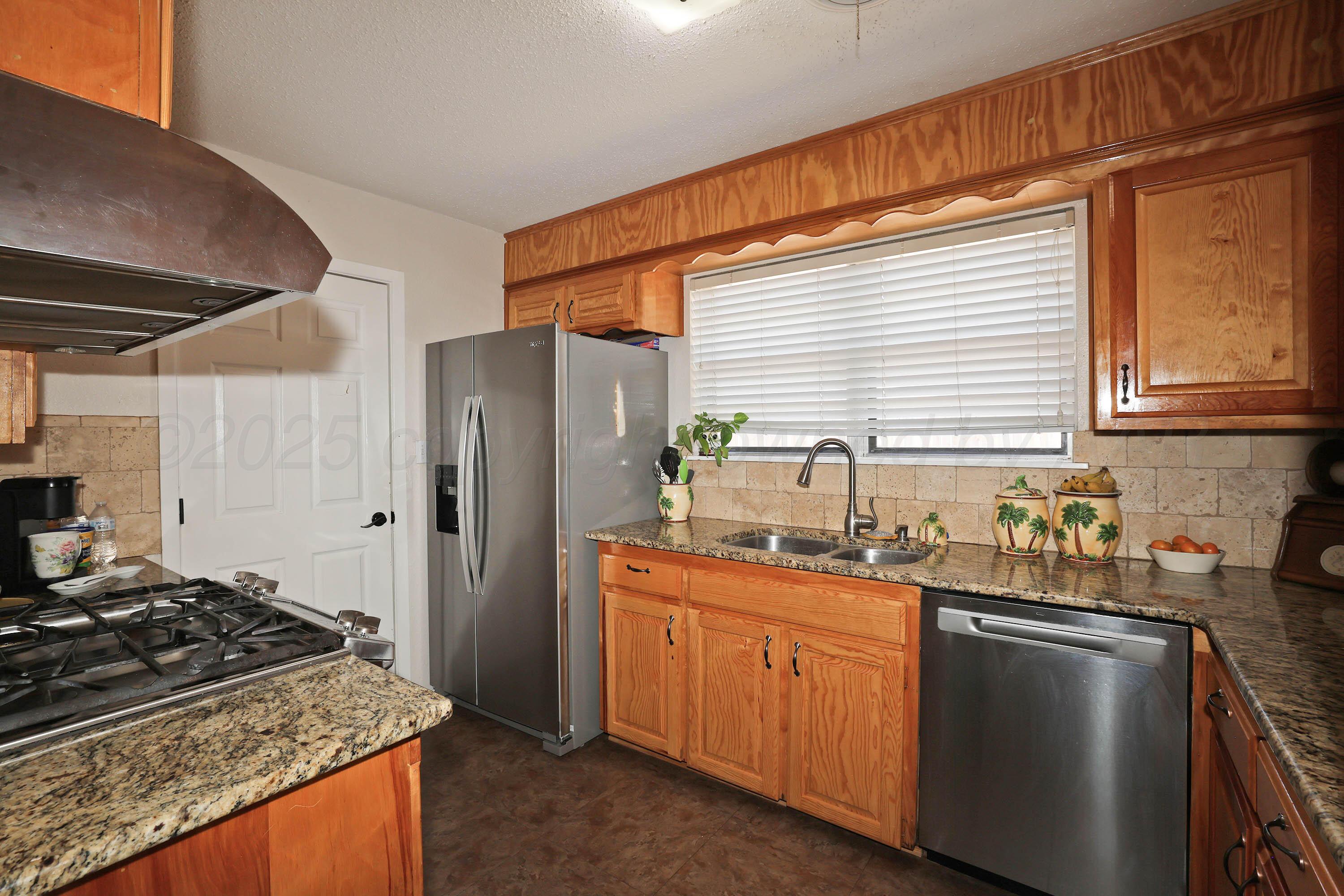 5811 Oregon Trail Amarillo, TX 79109 - Photo 7 of 22 a kitchen with a sink stove and refrigerator