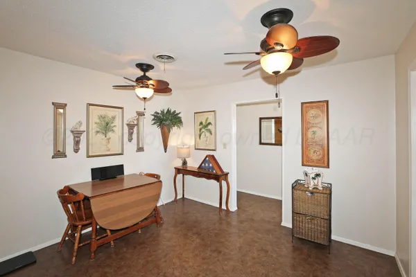 a room with chandelier fan and wooden floor