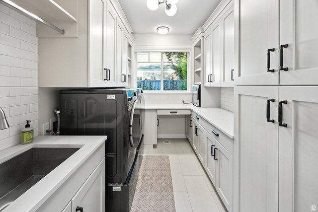 1774 Country Club Drive Logan, UT 84321 - Photo 9 of 28 Bright utility room featuring white shaker-style cabinetry, a built-in workstation, undermount sink, and a window providing natural light