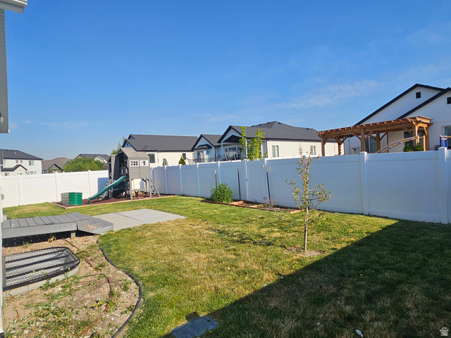 2508 Sunset Way Layton, UT 84041 - Photo 19 of 35 Expansive backyard featuring a manicured lawn, a concrete patio area, and a white vinyl privacy fence