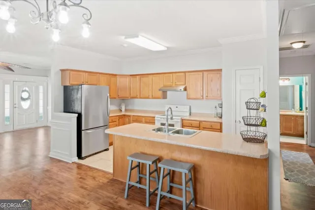 a kitchen with stainless steel appliances granite countertop a sink refrigerator and cabinets