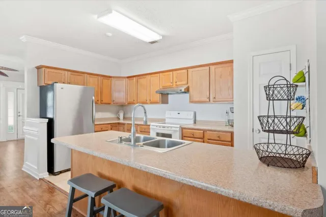 a kitchen with stainless steel appliances granite countertop a sink and a refrigerator