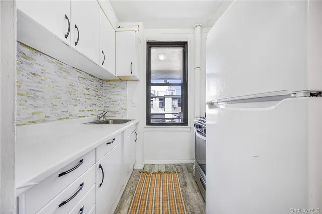 a kitchen with granite countertop a stove and a refrigerator