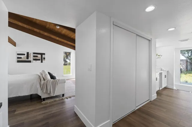 a hallway with wooden floor windows and stairs