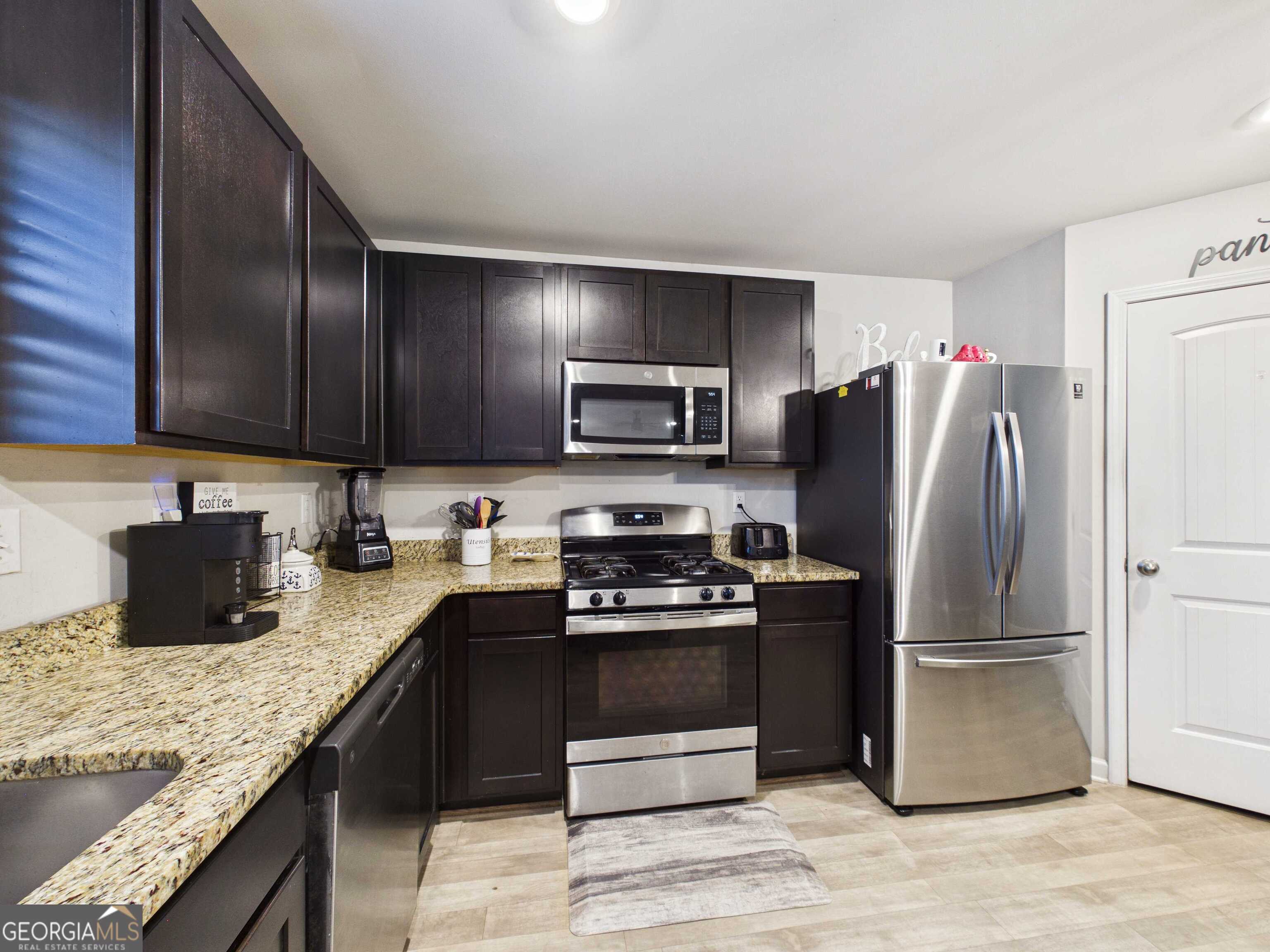 197 Stocks Circle West Point, GA 31833 - Photo 53 of 63 a kitchen with stainless steel appliances granite countertop a stove a refrigerator and a sink