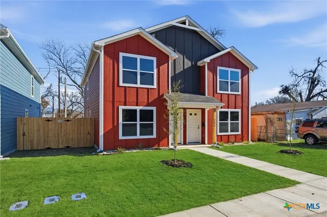a front view of a house with a garden and yard