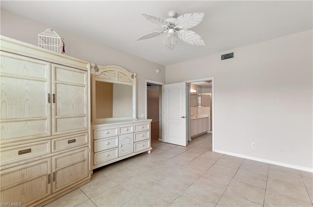 9341 Spring Run Boulevard, Unit 3106 Estero, FL 34135 - Photo 21 of 44 Unfurnished bedroom with light tile floors, a ceiling fan, and connected bathroom