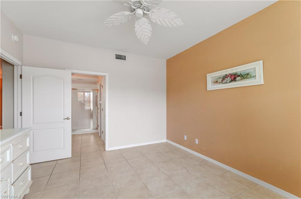 9341 Spring Run Boulevard, Unit 3106 Estero, FL 34135 - Photo 22 of 44 Unfurnished bedroom featuring light tile floors, a ceiling fan, and ensuite bath