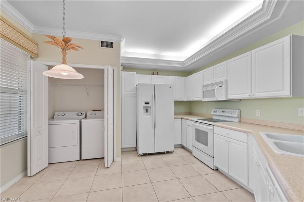 9341 Spring Run Boulevard, Unit 3106 Estero, FL 34135 - Photo 4 of 44 Kitchen featuring white appliances, light countertops, decorative light fixtures, white cabinetry, and light tile flooring