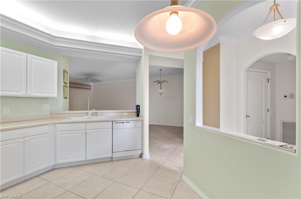 9341 Spring Run Boulevard, Unit 3106 Estero, FL 34135 - Photo 6 of 44 Kitchen featuring light countertops, white cabinetry, dishwasher, light tile patterned flooring, and pendant lighting