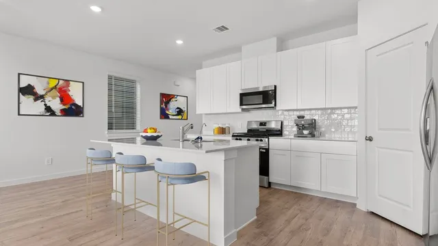 a kitchen with white cabinets and sink