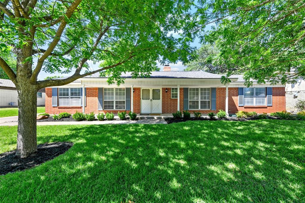 a front view of a house with a yard and green space