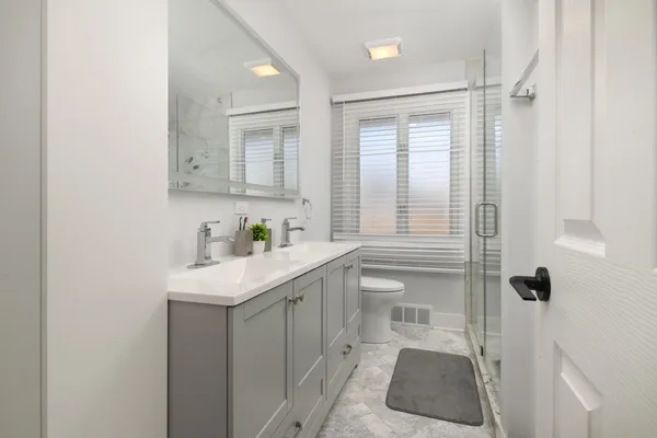 a bathroom with a sink a toilet and shower