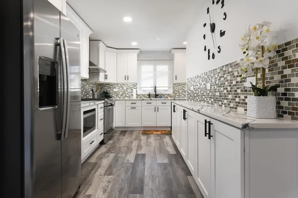 a kitchen with stainless steel appliances kitchen island granite countertop a stove and a refrigerator