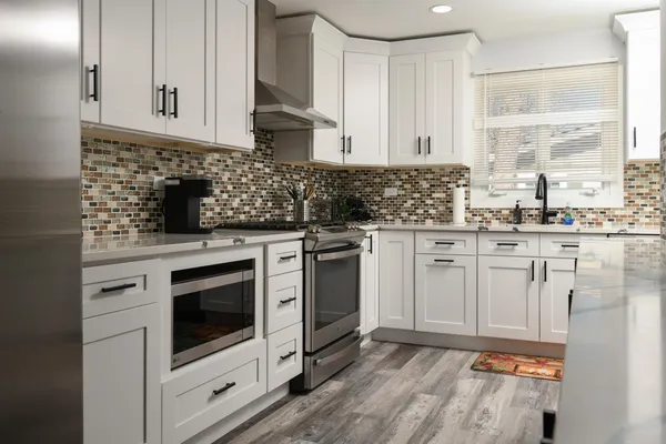 a kitchen with granite countertop white cabinets stainless steel appliances and sink