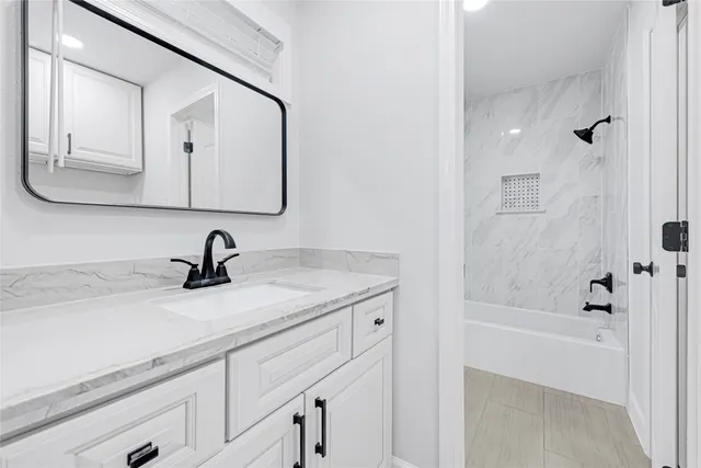a view of an empty room with wooden floor and a ceiling fan