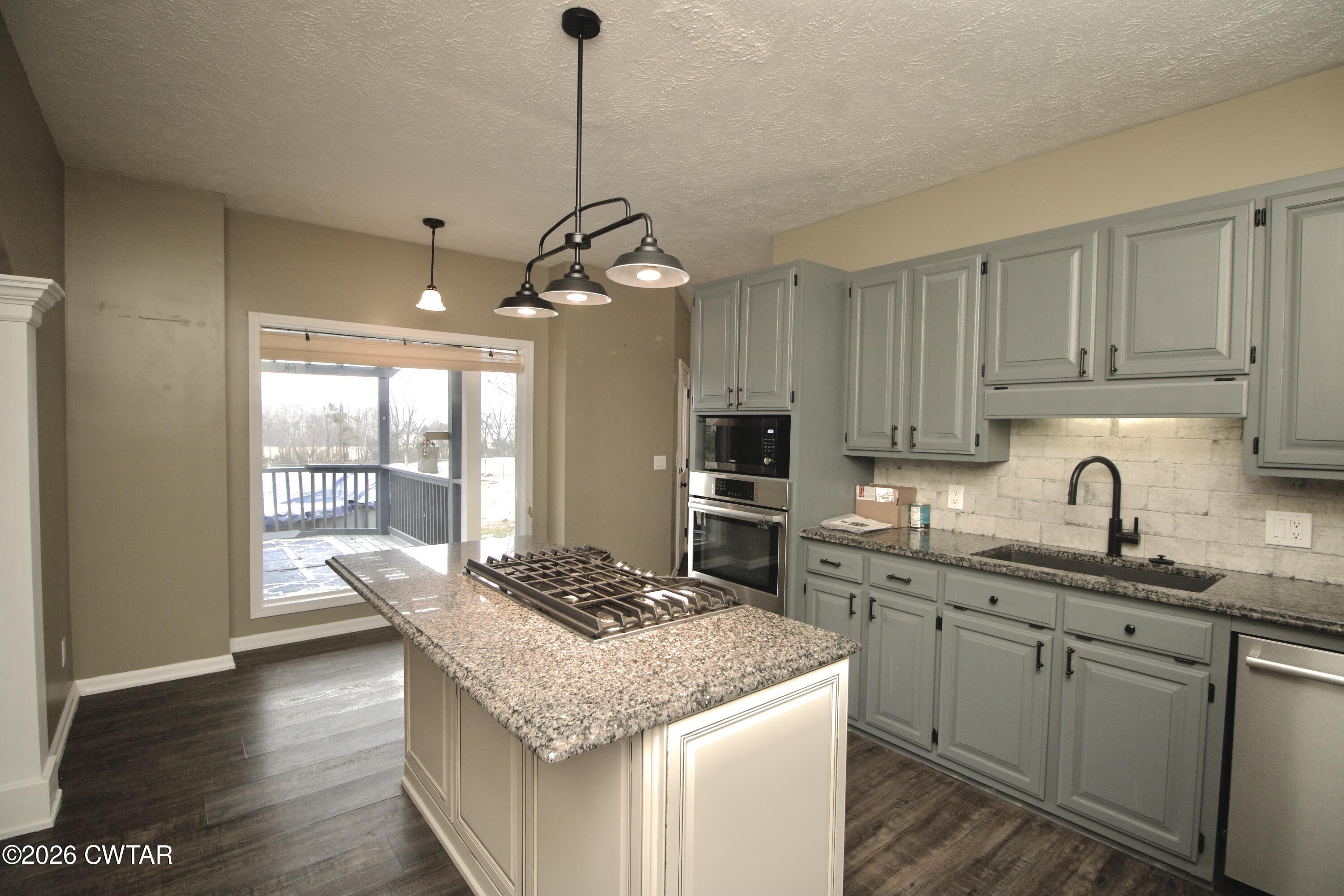 2845 Gilchrist Stantonville Road Stantonville, TN 38379 - Photo 23 of 97 a kitchen with a center island a sink cabinets and wooden floor