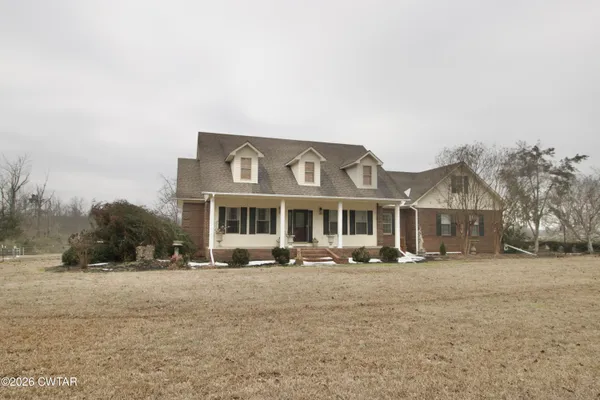 a front view of a house with a yard covered in snow