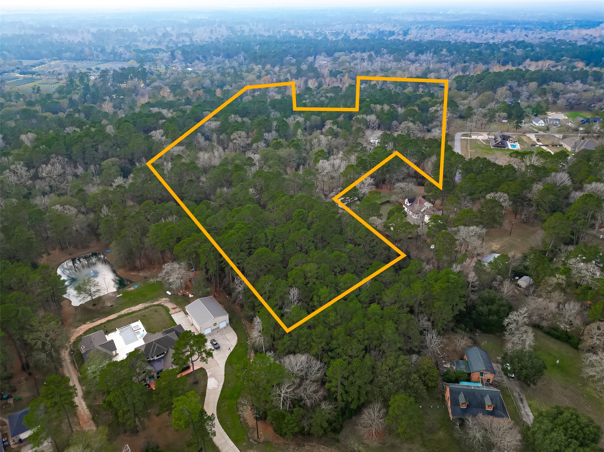 Aerial view highlighting the subject property within a private, wooded setting. Lines are approximate and should be independently verified.