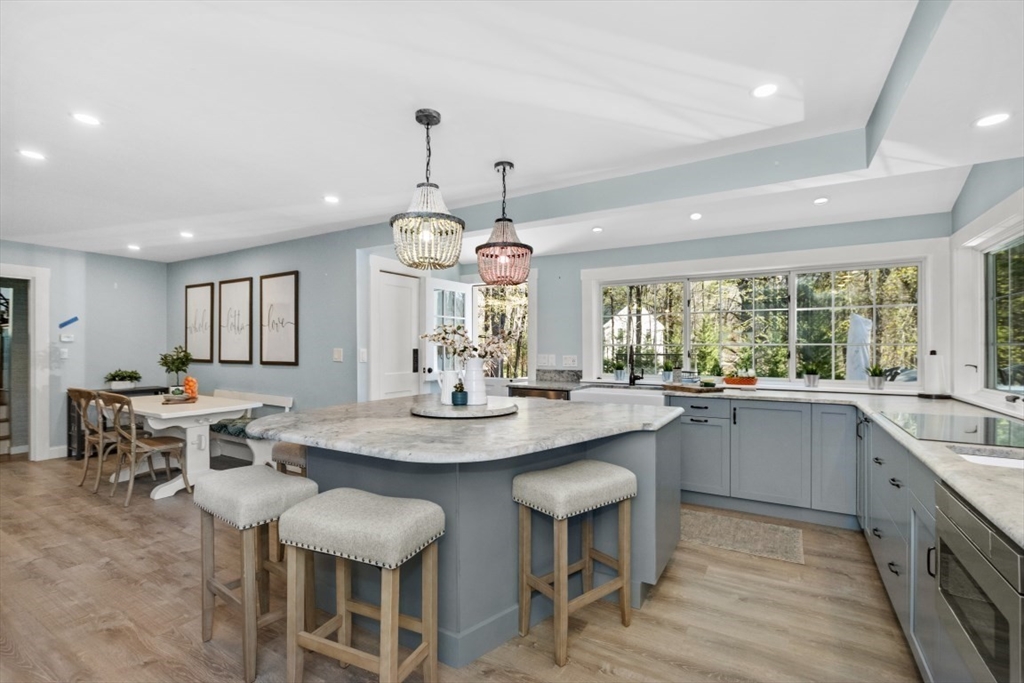 a kitchen with stainless steel appliances granite countertop a table and chairs in it