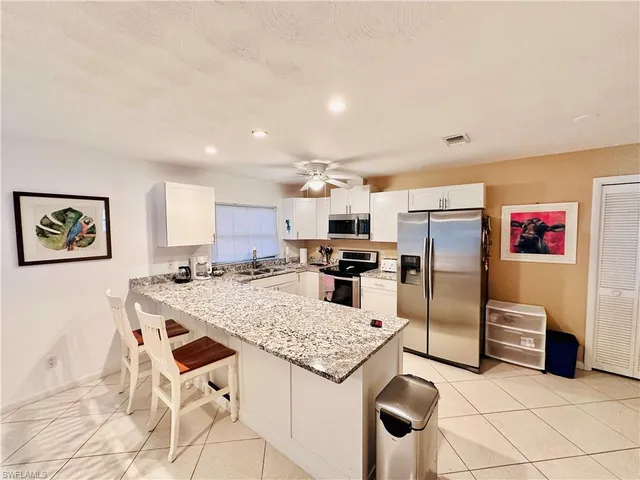 a kitchen with stainless steel appliances kitchen island granite countertop a refrigerator and a stove