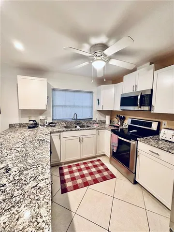 a kitchen with stainless steel appliances granite countertop a stove sink and cabinets