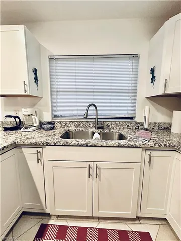 a kitchen with granite countertop a sink and cabinets