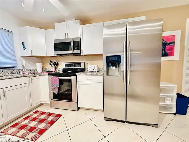 a kitchen with stainless steel appliances granite countertop a refrigerator and a stove top oven