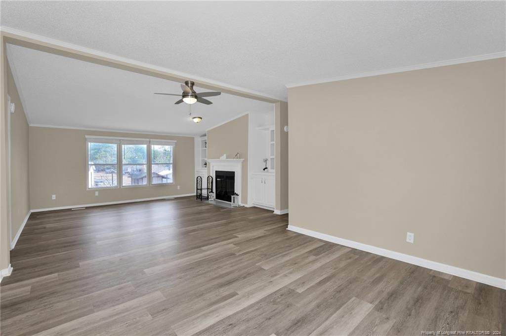 51 Old Forte Trail Spring Lake, NC 28390 - Photo 11 of 33 an empty room with wooden floor and windows