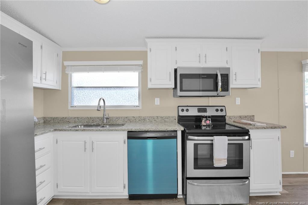 51 Old Forte Trail Spring Lake, NC 28390 - Photo 12 of 33 a kitchen with stainless steel appliances granite countertop a stove a microwave and a sink