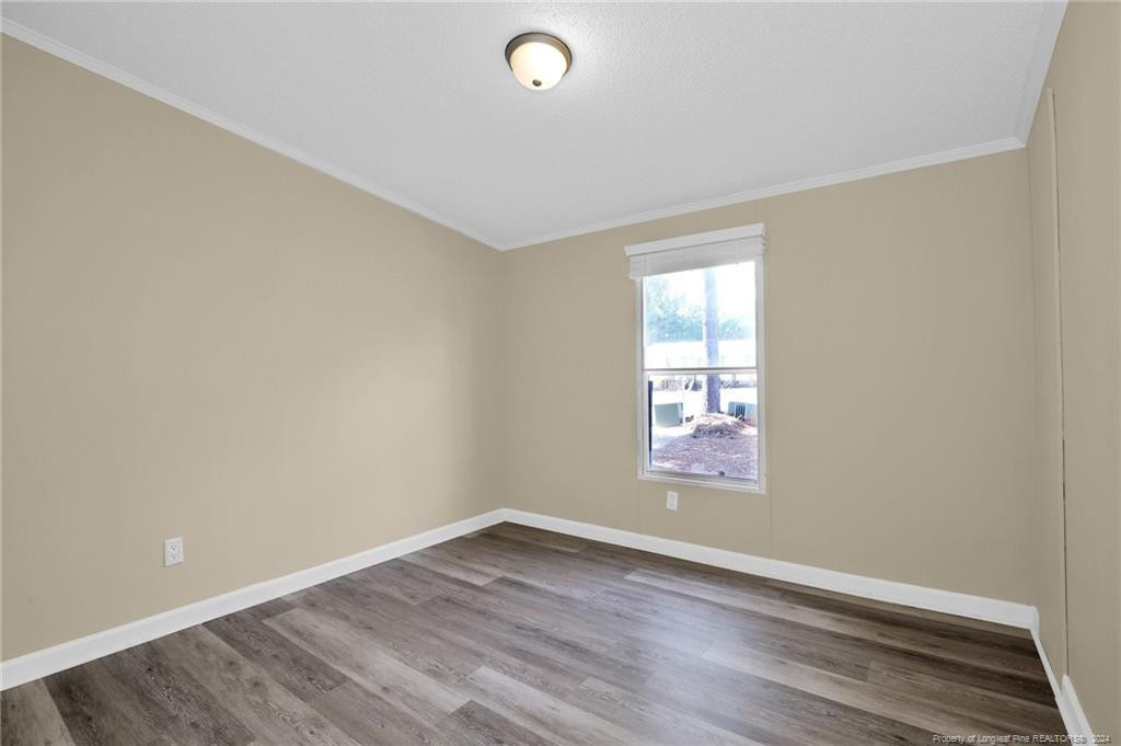51 Old Forte Trail Spring Lake, NC 28390 - Photo 24 of 33 an empty room with wooden floor and windows