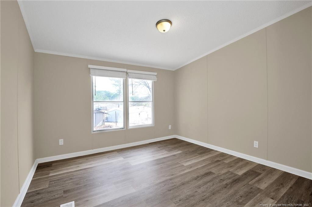 51 Old Forte Trail Spring Lake, NC 28390 - Photo 26 of 33 an empty room with wooden floor and windows