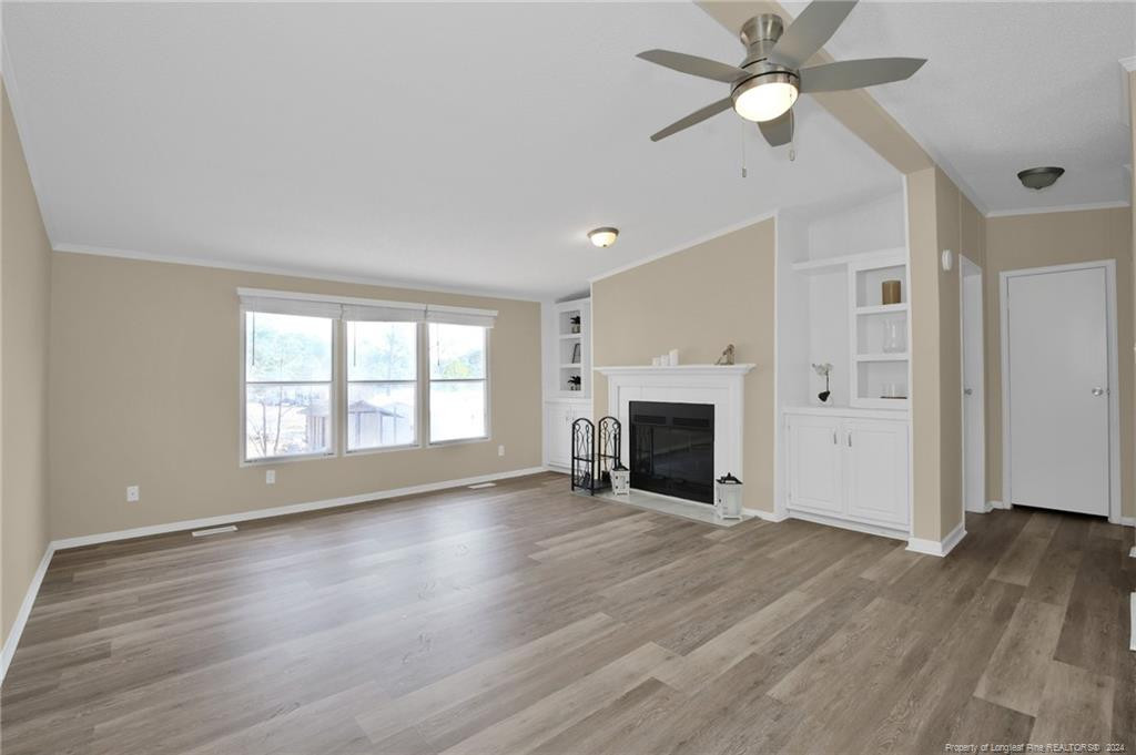 51 Old Forte Trail Spring Lake, NC 28390 - Photo 6 of 33 an empty room with wooden floor fan and windows