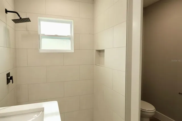 a bathroom with a toilet and a shower