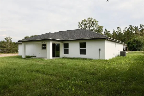 a house with green field in front of it