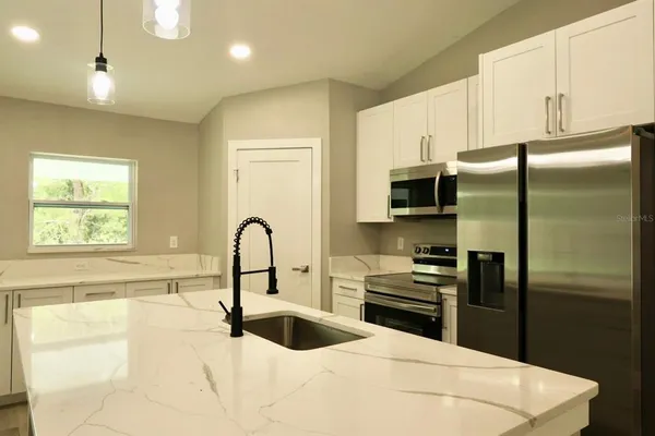 a kitchen with a refrigerator and a sink